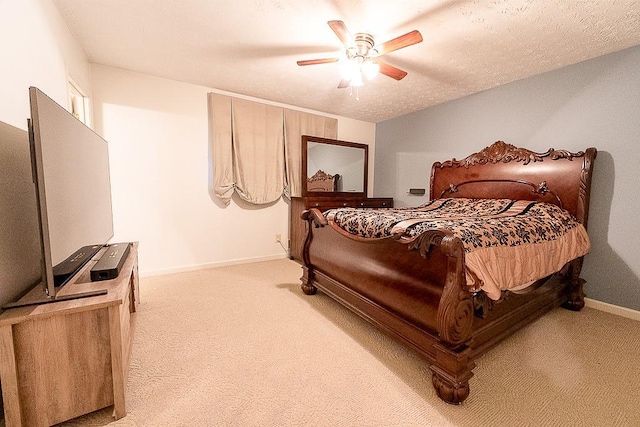 carpeted bedroom with ceiling fan and a textured ceiling