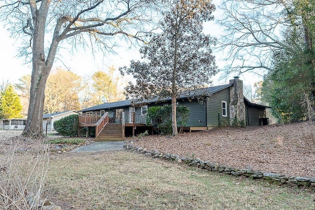 rear view of house with a yard and a deck