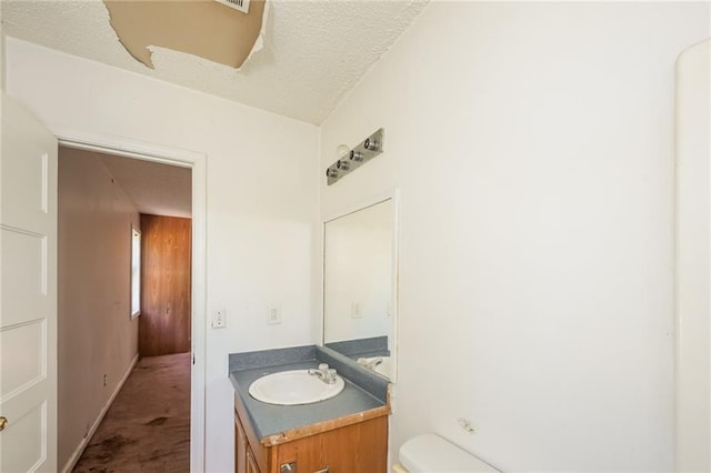 2325 E Hill Way, Norcross, GA 30071 - half bath featuring vanity, toilet, and a textured ceiling