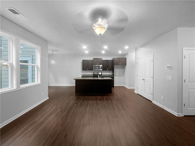 unfurnished living room with ceiling fan and dark hardwood / wood-style floors