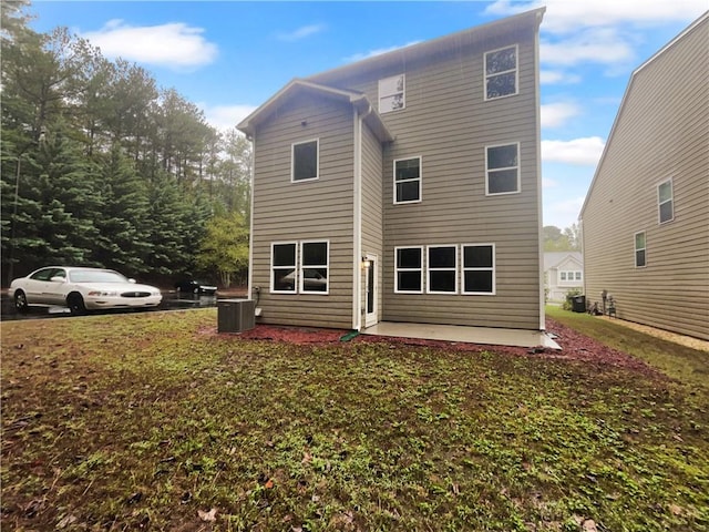 rear view of house featuring a patio, central AC, and a yard