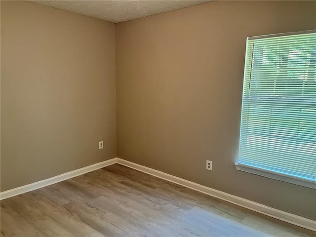 7400 Little Fawn Pkwy, Palmetto, GA 30268 - unfurnished room featuring wood finished floors, healthy amount of natural light, and a textured ceiling