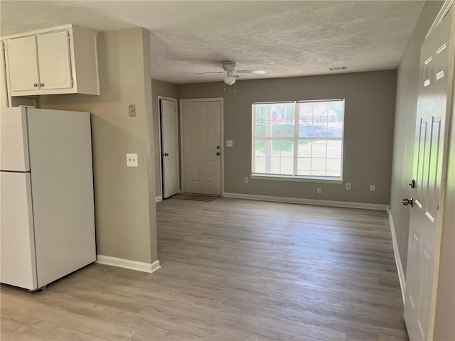 7400 Little Fawn Pkwy, Palmetto, GA 30268 - kitchen with freestanding refrigerator, white cabinetry, a textured ceiling, a ceiling fan, and light wood-style flooring