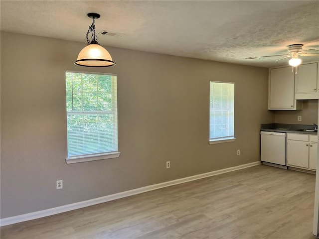 7400 Little Fawn Pkwy, Palmetto, GA 30268 - kitchen featuring dishwasher, light wood-style floors, a ceiling fan, dark countertops, and a textured ceiling
