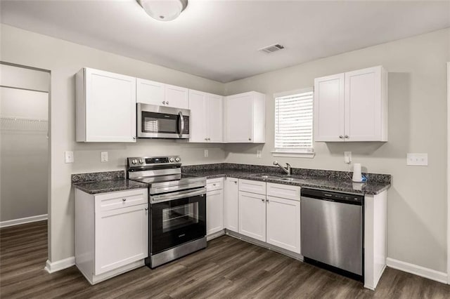 325 Nutwood Trce, Locust Grove, GA 30248 - kitchen with appliances with stainless steel finishes, a sink, dark wood-type flooring, white cabinetry, and baseboards