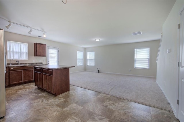kitchen with light colored carpet, baseboards, visible vents, and a healthy amount of sunlight