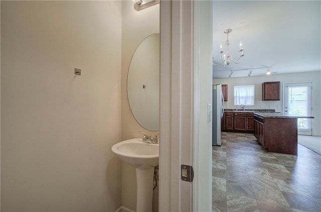 bathroom with an inviting chandelier and a sink