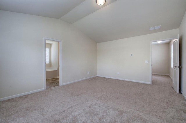 unfurnished bedroom featuring visible vents, baseboards, connected bathroom, carpet, and lofted ceiling