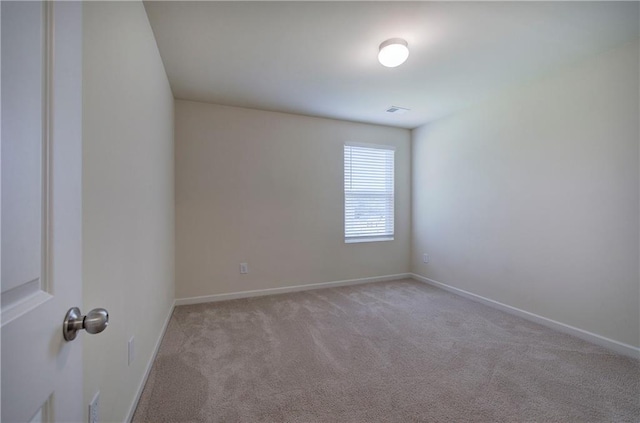 unfurnished room with baseboards, visible vents, and light carpet