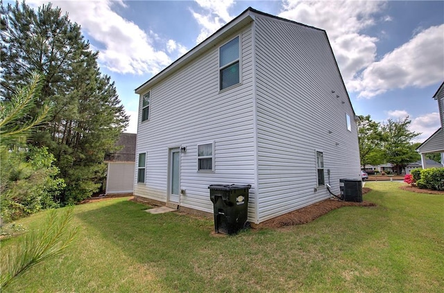 back of house featuring a lawn and central AC