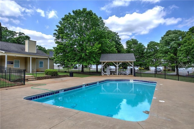 pool with a patio, fence, and a gazebo