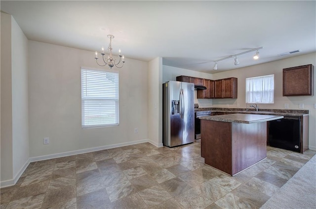 kitchen featuring visible vents, a center island, a chandelier, a sink, and appliances with stainless steel finishes