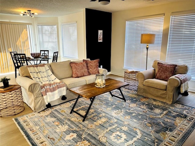 living room with ceiling fan, hardwood / wood-style floors, and a textured ceiling