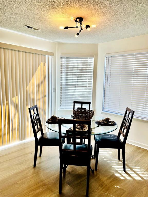 dining area with a textured ceiling and hardwood / wood-style flooring