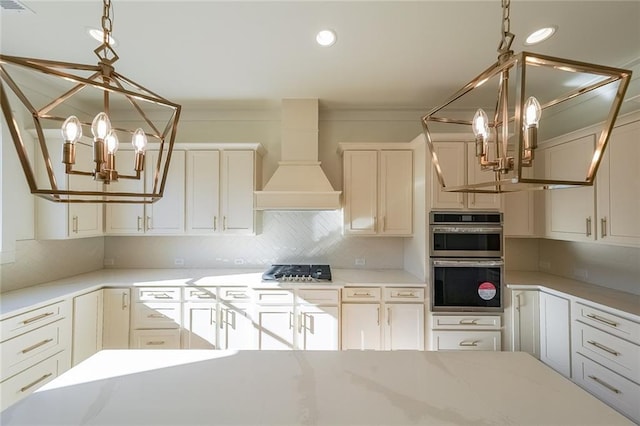 kitchen featuring white cabinets, stainless steel appliances, an inviting chandelier, backsplash, and custom range hood