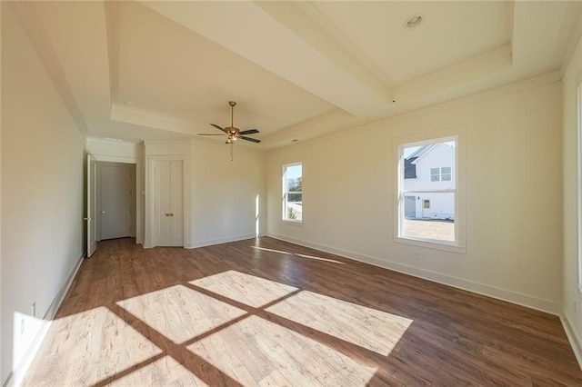 unfurnished room featuring ceiling fan, a tray ceiling, and hardwood / wood-style floors