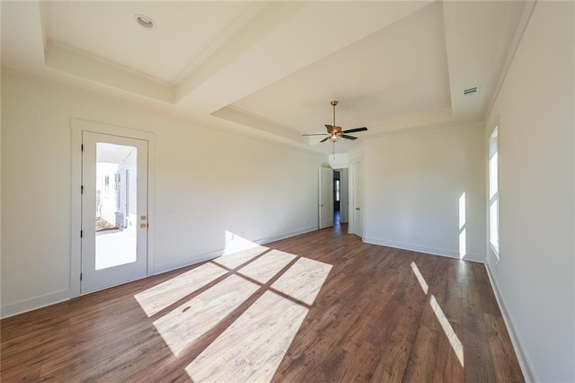 unfurnished room featuring ceiling fan, crown molding, dark hardwood / wood-style floors, and a raised ceiling