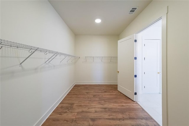 walk in closet with wood-type flooring