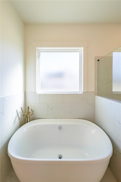 bathroom with a wealth of natural light and a bath