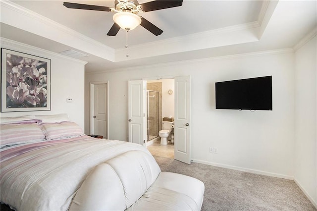 carpeted bedroom featuring a raised ceiling, crown molding, ensuite bathroom, and ceiling fan