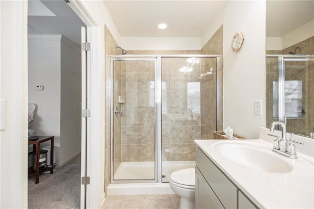 bathroom with a shower with door, vanity, and toilet