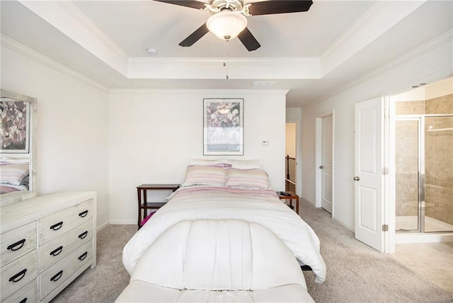 bedroom featuring crown molding, ensuite bath, a tray ceiling, and light carpet