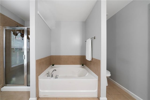 bathroom with a stall shower, tile patterned floors, a garden tub, toilet, and baseboards