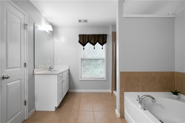 full bathroom featuring a garden tub, vanity, tile patterned floors, baseboards, and a shower with door