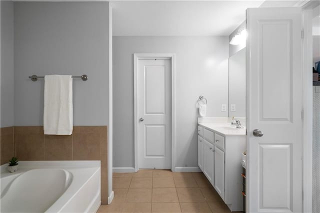 full bathroom featuring tile patterned flooring, a garden tub, vanity, and baseboards