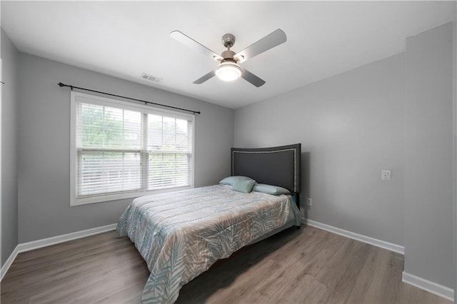 bedroom featuring wood finished floors, baseboards, and ceiling fan