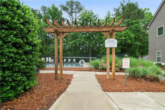 view of community featuring a pool and fence