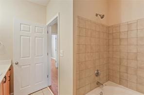 bathroom featuring vanity and tiled shower / bath