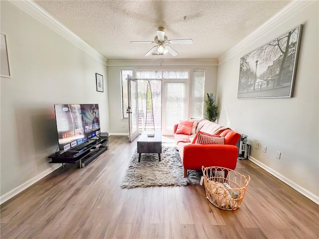 living room with a textured ceiling, hardwood / wood-style flooring, crown molding, and ceiling fan