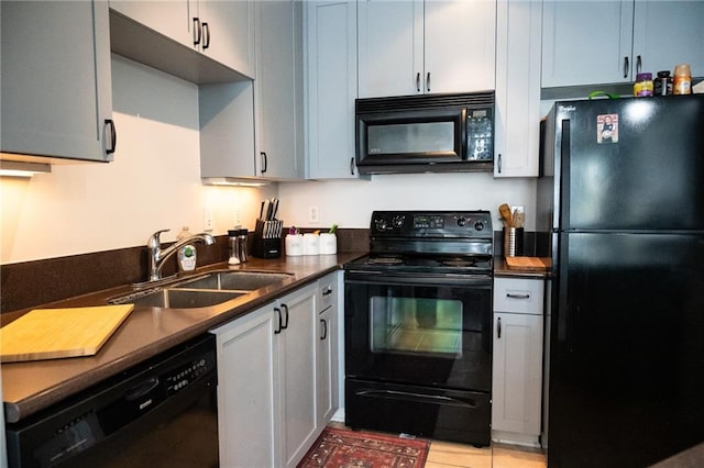 kitchen featuring light tile patterned floors, black appliances, and sink