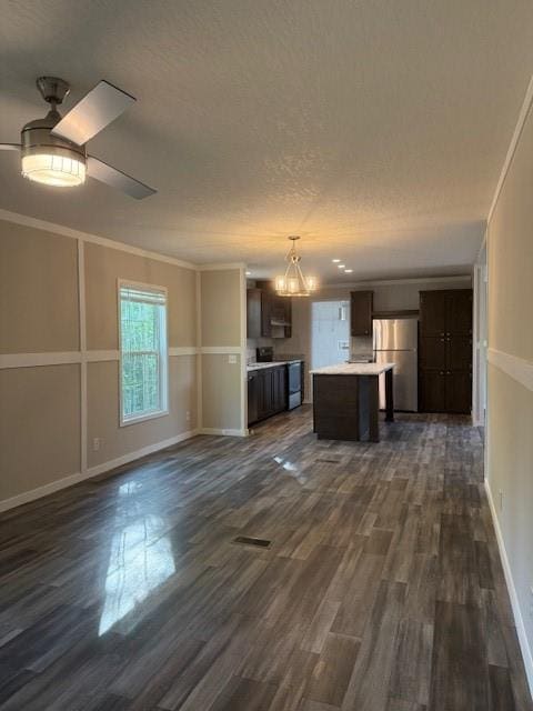 332 Dewaters Rd, Commerce, GA 30529 - unfurnished living room with dark wood-style floors, a chandelier, baseboards, ceiling fan, and ornamental molding