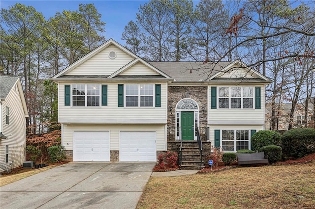 1559 Hillary Cove Ct, Lawrenceville, GA 30043 - split foyer home featuring driveway, stone siding, an attached garage, central AC, and a front yard