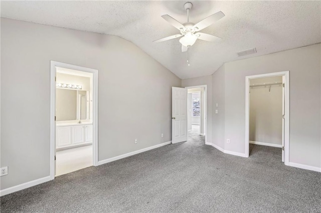 1559 Hillary Cove Ct, Lawrenceville, GA 30043 - unfurnished bedroom with a textured ceiling, lofted ceiling, carpet flooring, baseboards, and a spacious closet