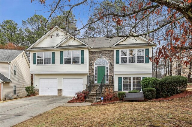1559 Hillary Cove Ct, Lawrenceville, GA 30043 - raised ranch featuring stone siding, a garage, concrete driveway, and a front yard