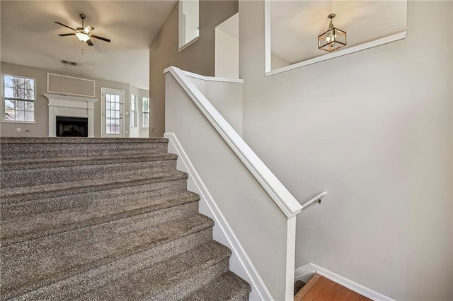 1559 Hillary Cove Ct, Lawrenceville, GA 30043 - stairway featuring ceiling fan, baseboards, and a fireplace