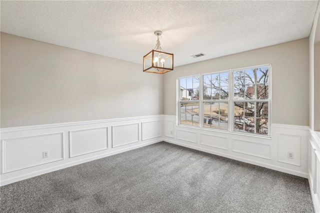 1559 Hillary Cove Ct, Lawrenceville, GA 30043 - unfurnished dining area featuring carpet flooring, a chandelier, a wainscoted wall, a textured ceiling, and a decorative wall