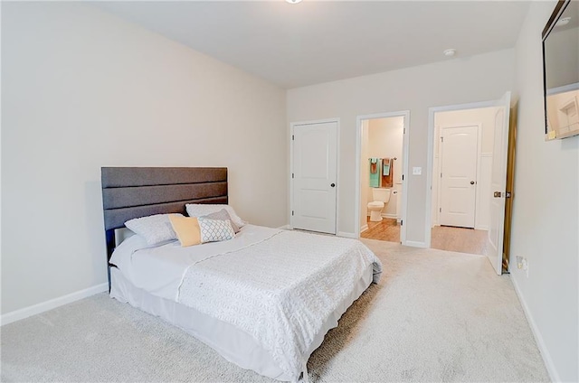bedroom featuring carpet floors, ensuite bath, and baseboards