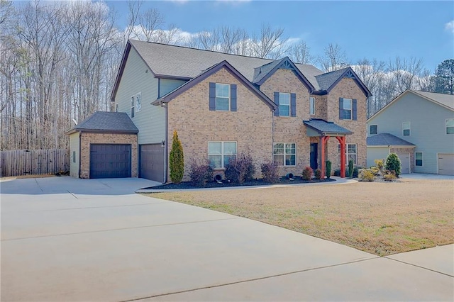 view of front of home featuring driveway, a front yard, fence, brick siding, and a garage