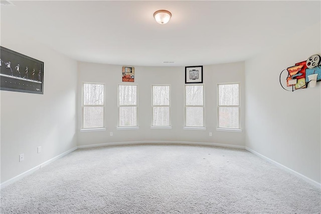 spare room featuring baseboards and carpet flooring