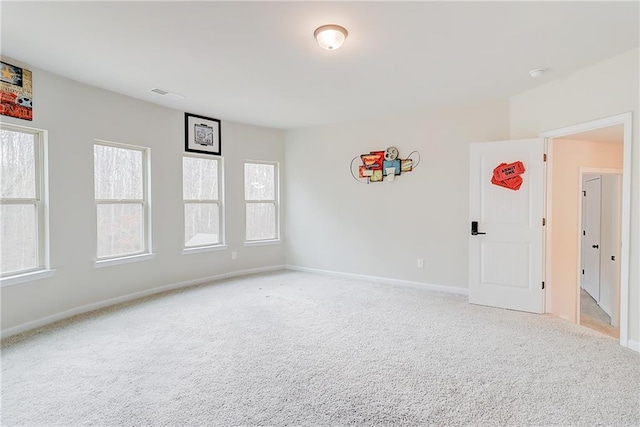 carpeted spare room with baseboards and visible vents