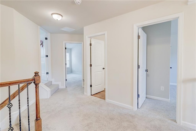 hallway featuring carpet floors and baseboards