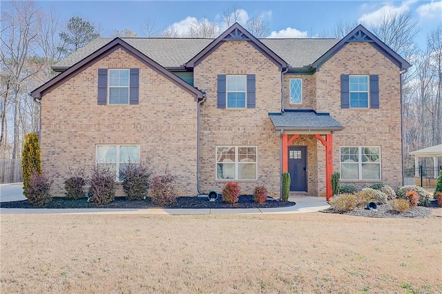 view of front of home featuring brick siding and a front lawn