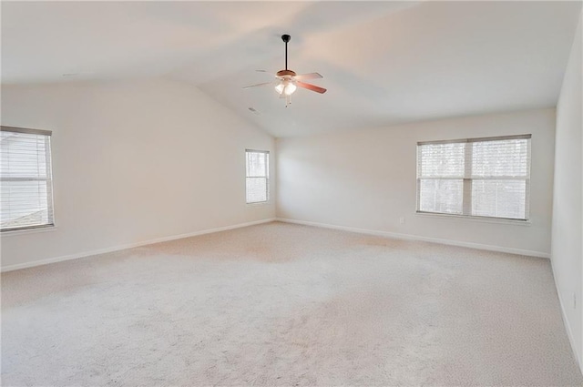 spare room featuring carpet flooring, a ceiling fan, baseboards, and lofted ceiling