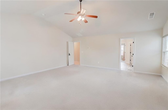 spare room featuring light colored carpet, baseboards, ceiling fan, and visible vents