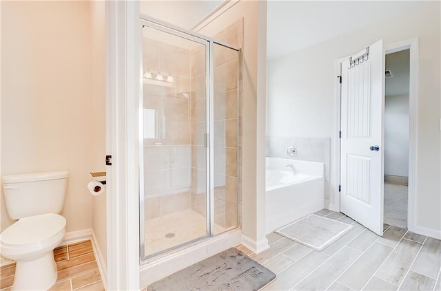full bath featuring a shower stall, toilet, a bath, and wood finish floors