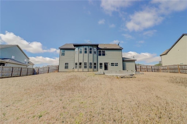 back of house with a fenced backyard